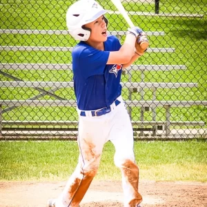 Youth baseball player swinging a bat during a game.